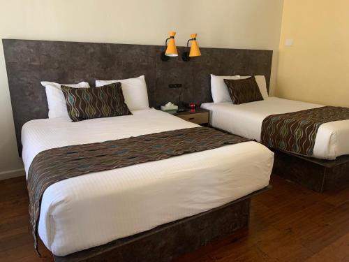 Ένα ή περισσότερα κρεβάτια σε δωμάτιο στο Oasis Inn and Suites