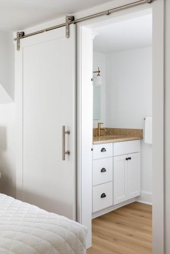 a bedroom with a sliding door leading into a bathroom at Inn on the Beach in Harwich Port