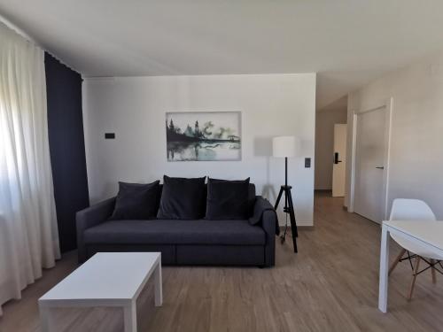 a living room with a couch and a table at Apartamentos Seijo in Villalba