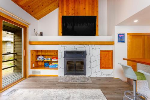 a living room with a fireplace and a tv at Snowbird Condo 195 - C in Girdwood