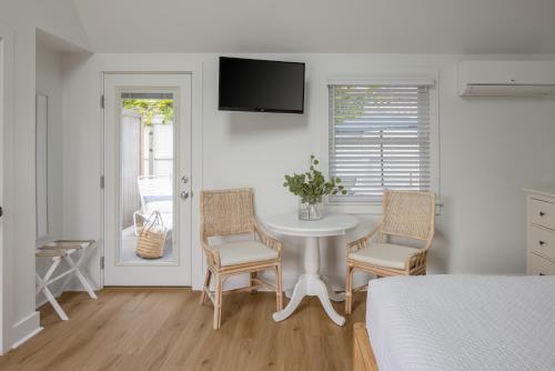 a bedroom with a table and chairs and a bed at Inn on the Beach in Harwich Port