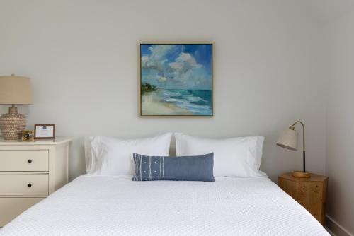 a bedroom with a white bed with a blue pillow at Inn on the Beach in Harwich Port