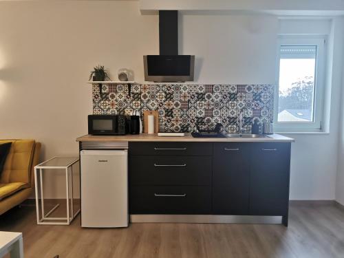 a kitchen with a black counter top with a microwave at Apartamentos Seijo in Villalba