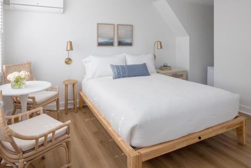 a bed in a room with a table and a chair at Inn on the Beach in Harwich Port