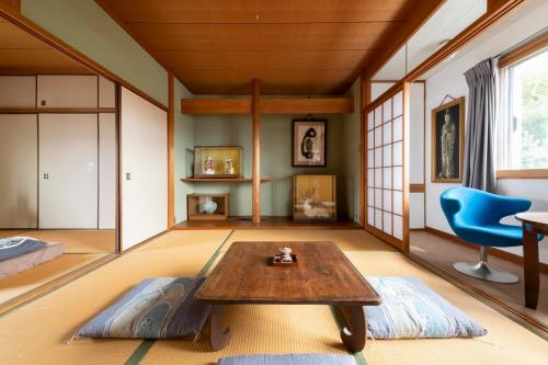 un soggiorno con tavolo e sedia blu di Niwamori_org a Nara