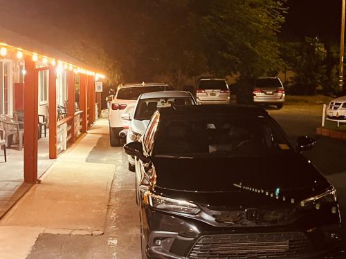 a group of cars parked on a street at night at Jumping Frog Motel in Angels Camp