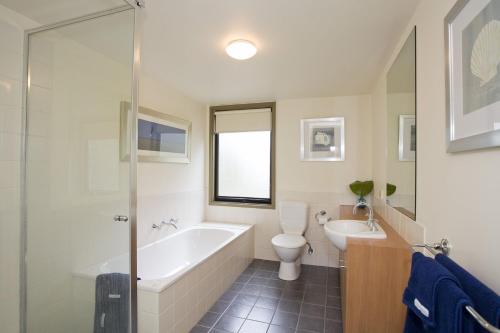 a bathroom with a tub and a toilet and a sink at Purfect Purnell in Anglesea