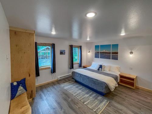 a bedroom with a large bed and two windows at Talkeetna Wilderness Lodge & Cabin Rentals in Sunshine