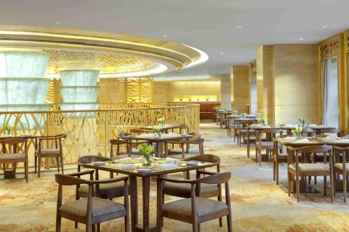 a restaurant with tables and chairs in a room at Radisson Blu Hotel Shanghai New World in Shanghai