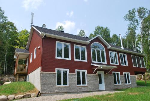 a house with a red house at Chalets Lanaudière in Rawdon