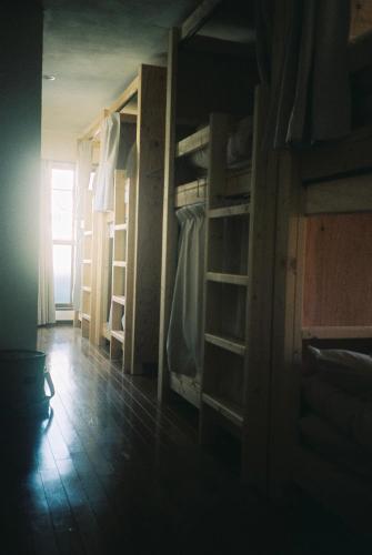 a room with several bunk beds and a window at ゲストハウスよるよなか in Nagoya