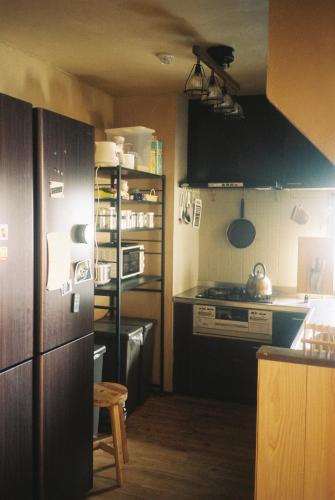 a kitchen with a stove and a counter top at ゲストハウスよるよなか in Nagoya