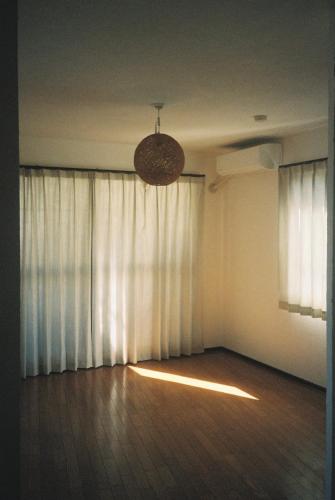 a room with a large window with a light at ゲストハウスよるよなか in Nagoya