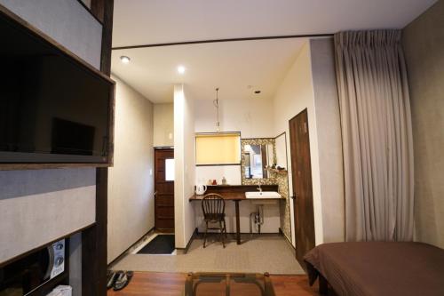 a room with a bed and a kitchen with a desk at Traditional Apartment Takamatsu Guesthouse in Takamatsu