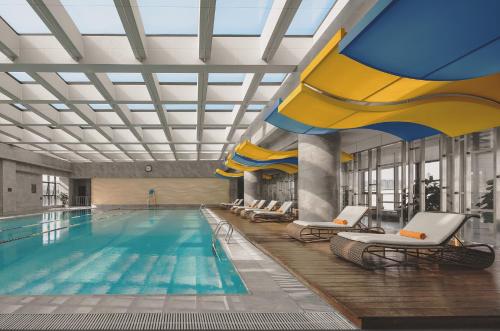 西安的住宿－西安盛美利亞酒店，一个带椅子的游泳池和一个游泳池