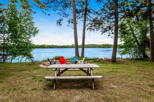 a picnic table in front of a lake at Whispering Pines in Harshaw