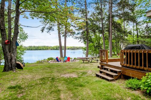a campsite with a picnic table and a lake at Whispering Pines in Harshaw