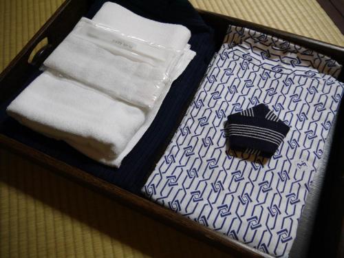 a suitcase with towels and a brush in it at Koyasan Shukubo Yochiin in Koyasan