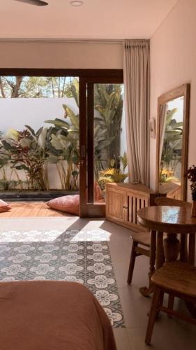 a bedroom with a bed and a table and a mirror at The Seaglass Villas Bingin in Uluwatu