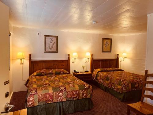 a hotel room with two beds and two lamps at Jumping Frog Motel in Angels Camp