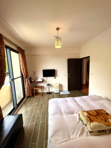 a bedroom with a large bed and a television at 溪頭18號 in Lugu