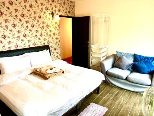 a bedroom with a bed with a chair and a couch at 溪頭18號 in Lugu