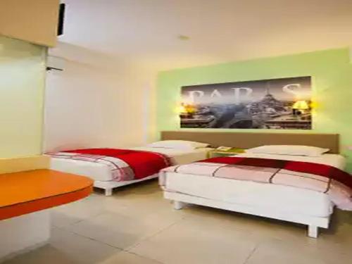 1 dormitorio con 2 camas y un cuadro en la pared en Dewarna Hotel Arifin, en Malang