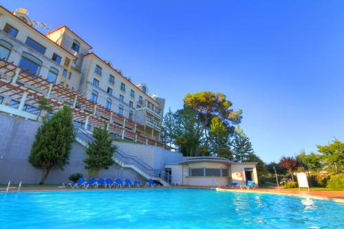 a swimming pool in front of a building at Lam Hotel Estarreja in Estarreja