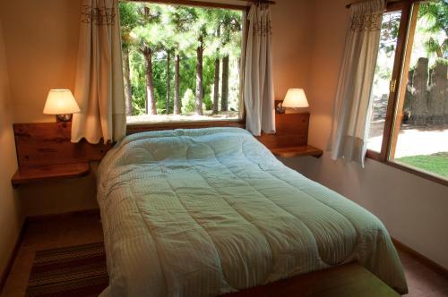 a bedroom with a bed and a window at KaiKen Lauquen in Trevelin
