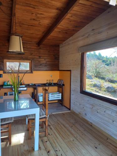 uma sala de jantar com uma mesa e uma janela em Cabaña de Campo - Valle de Calamuchita - Sierras de Córdoba em San Clemente del Tuyú