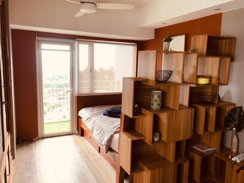 a bedroom with a bed and a book shelf at Wind Residence Designer Appt overlooking Taal lake - Tower 1 - 42sqm in Tagaytay