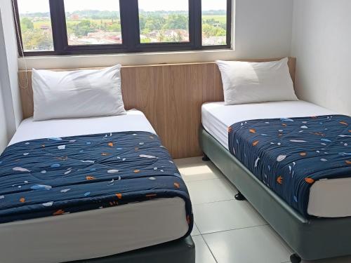 two beds in a room with two windows at NZ Residence-Imperio Alor Setar 3BR Homestay Apartment in Alor Setar