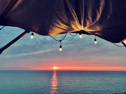 a sunset over the ocean with lights on a tent at AWAJI OCEAN BASE west coast in Tusi