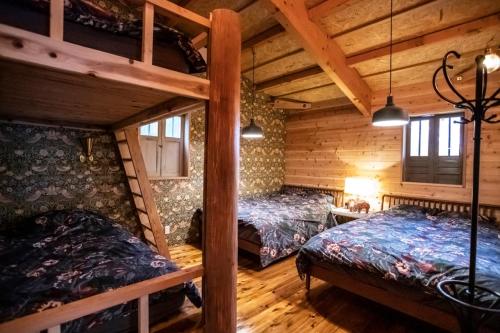 a bedroom with two bunk beds in a cabin at First Class Backpackers Inn DAISEN - FBI DAISEN in Daisen
