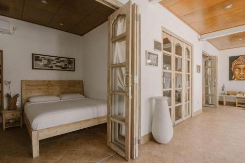 1 dormitorio con 1 cama y armario de madera en Bale Seminyak, en Seminyak