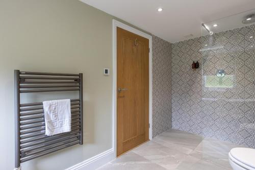 a bathroom with a toilet and a wooden door at Eagles Peak in Allerston