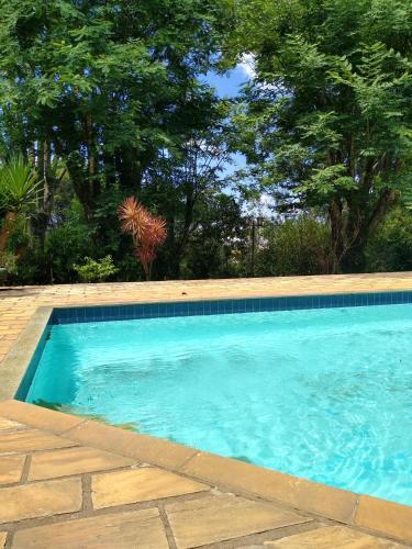 a swimming pool with blue water in a yard at Apart Res Swiss - Jd Europa in Santa Cruz do Sul