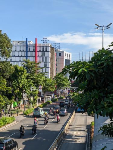a group of people riding motorcycles down a city street at Cordela Senen Jakarta in Jakarta