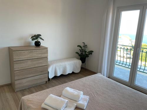 a bedroom with two beds and a dresser and a window at Apartments Angela in Primošten