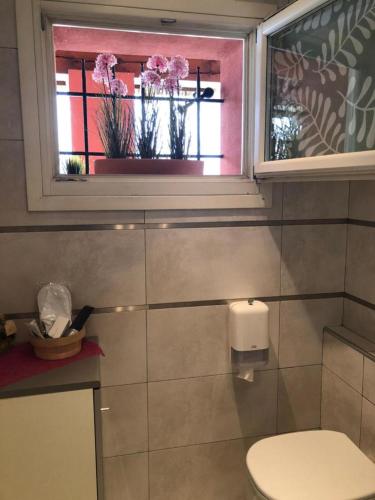 a bathroom with a toilet and a window with flowers at Room in BB - Casa Belvedere - complimentary Wifi and private parking in Veneto