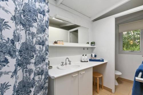 a bathroom with a sink and a shower curtain at Apollo Bay Beach Bungalow - Couples Retreat in Apollo Bay