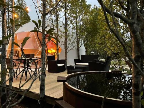 a deck with a tent and a table and chairs at Lodge Los Alerces in Los Muermos