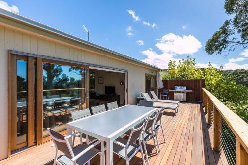 a patio with a white table and chairs on a deck at Strathlea in Lorne