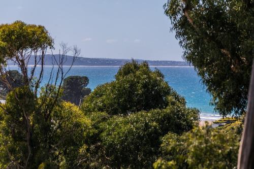 a view of a beach and the ocean with trees at Strathlea in Lorne