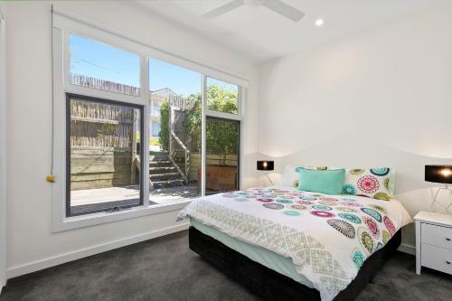 a bedroom with a bed and a large window at Strathlea in Lorne