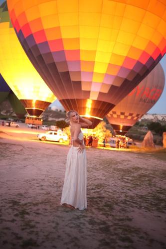 a woman standing in the water with hot air balloons at Mak's Cave House in Uchisar