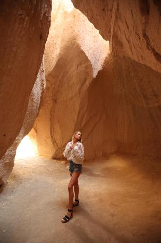 a woman is standing in a slot canyon at Mak's Cave House in Uchisar