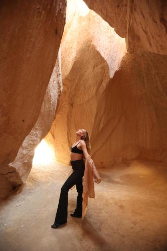 a woman dancing in a cave in a canyon at Mak's Cave House in Uchisar