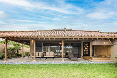 a house with a patio with a roof at Sesoko Sansui in Sesoko