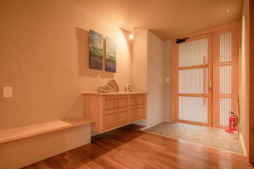 a living room with a large window and a wooden cabinet at Sesoko Sansui in Sesoko